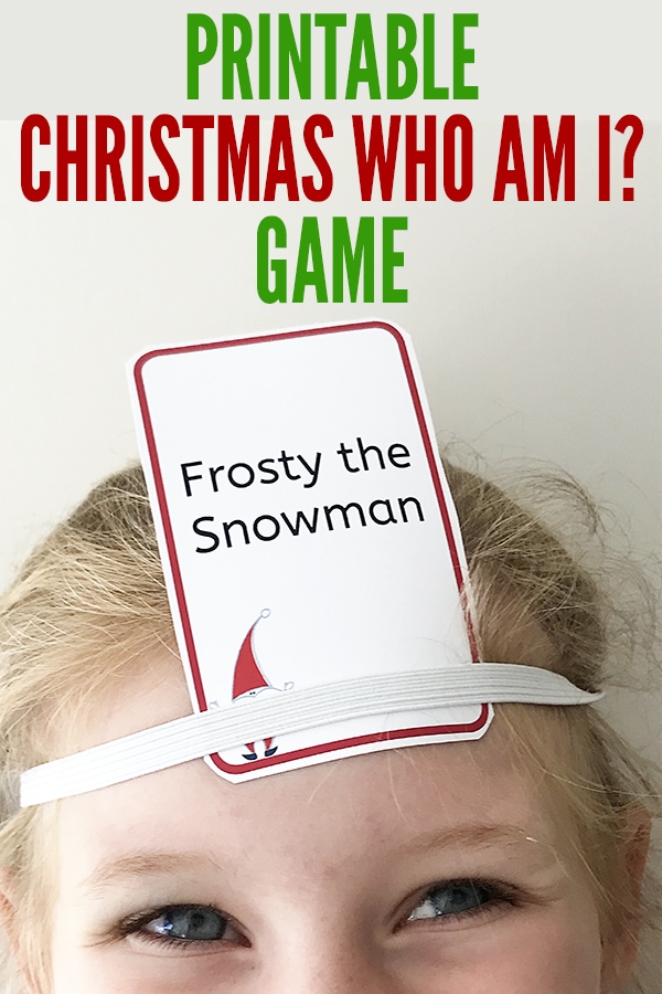 kid wearing festive holiday hats and holding cards playing the 'Christmas Who Am I' game, trying to guess the character or object they are assigned by asking yes or no questions