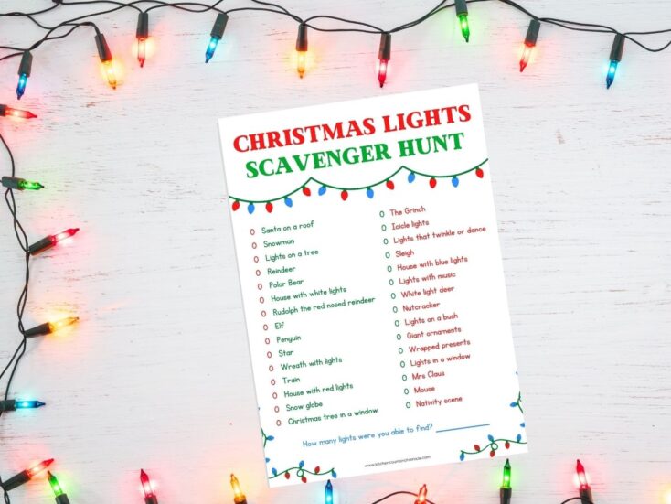 A printed Christmas lights scavenger hunt sheet placed on a table, surrounded by colorful Christmas lights